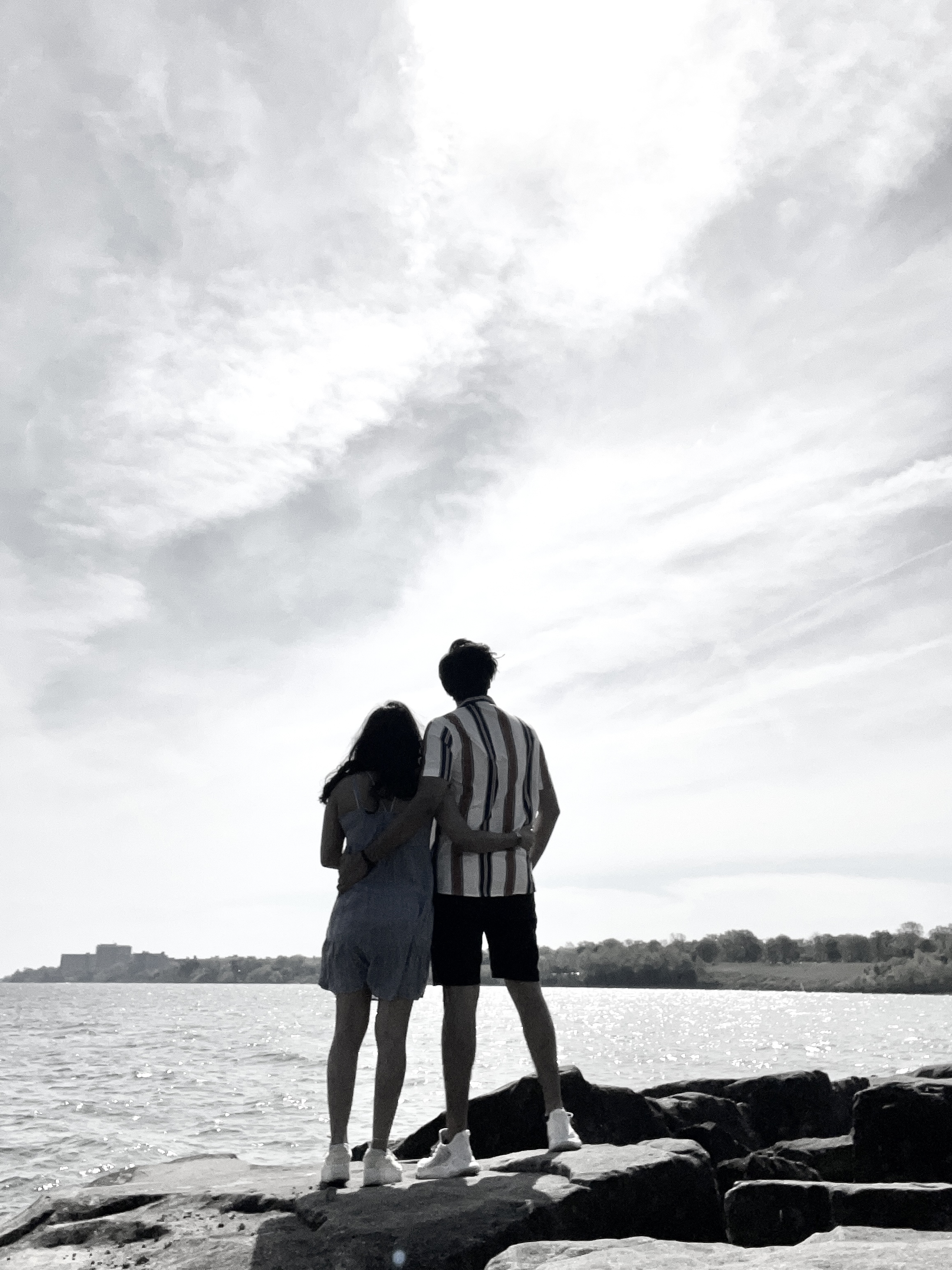 Jeel and Sheena silhouetted against the sky by the water